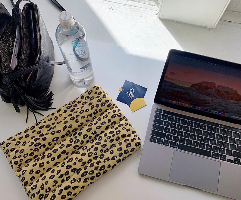 Laptop , purse and water bottle on desktop